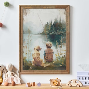 May include: A framed art print depicts a boy and a golden retriever dog sitting by a lake, fishing. The artwork has a rustic wooden frame and a serene, painterly style, with a fishing rod extending over the water.