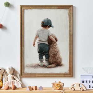 Puede incluir: Una pintura de un niño pequeño con una gorra de béisbol azul y una camisa gris, de pie con el brazo alrededor de un perro marrón. La pintura está enmarcada en un marco de madera marrón claro.