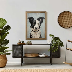 K&ouml;nnte beinhalten: Ein Portr&auml;t eines schwarz-wei&szlig;en Border Collies in einem gerahmten Gem&auml;lde, das &uuml;ber einem schwarzen Metallkonsolentisch mit einem geflochtenen Korb und einer Uhr auf der oberen Ablage h&auml;ngt.