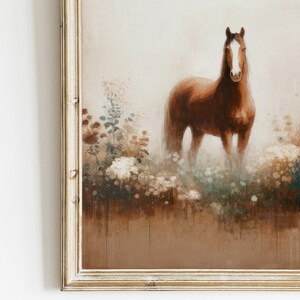 May include: A framed painting depicting a brown horse in a field of flowers. The horse has a white stripe on its face and a long mane. The artwork has a vintage, rustic style and is presented in a gold-coloured frame.