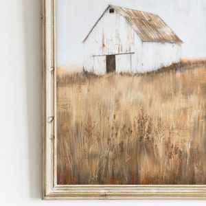 May include: A framed painting of a white barn with a brown roof in a field of tall, dry grass. The barn has a single door and a small window. The grass is a mix of brown, tan, and green.