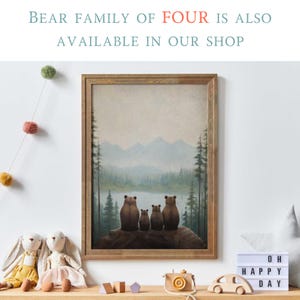 May include: A framed print of a family of four bears sitting on a log overlooking a lake and mountains. The bears are brown and the background is a soft blue and green.