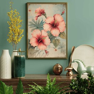 May include: A framed vintage botanical print featuring pink hibiscus flowers with green leaves on a light blue background.