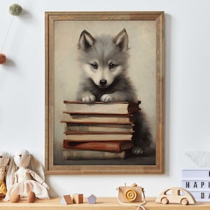 May include: A gray wolf pup sits on a stack of books. The wolf pup is looking at the camera with its head tilted slightly to the side. The books are stacked on a wooden table. The background is a light brown wall.
