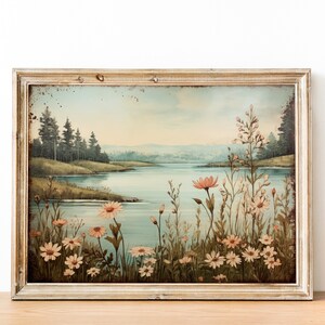 Puede incluir: Una impresi&oacute;n enmarcada de estilo vintage que representa una escena de lago con un bosque en el fondo. El lago est&aacute; rodeado de un campo de flores silvestres rosas y blancas.