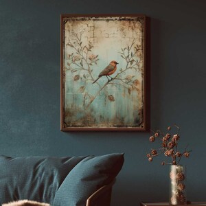 K&ouml;nnte beinhalten: Ein Vintage-Rahmenbild mit einem Vogel, der auf einem Zweig mit zarten Blumen sitzt. Der Hintergrund ist ein verblasster blauer und gr&uuml;ner Aquarell-Wasch mit einer abgenutzten Textur.