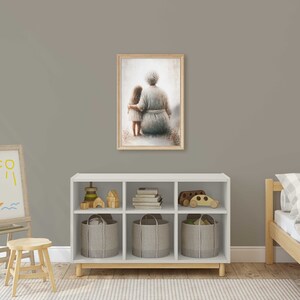 May include: A framed painting of an older woman and a young girl sitting together, both wearing light blue dresses. The painting is set against a light gray wall in a child's room with a white bookshelf, a wooden easel, and a wooden bed.