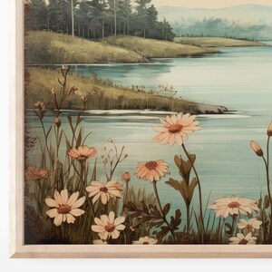 Puede incluir: Una pintura acuarela enmarcada que representa una escena de lago con un bosque en el fondo. En primer plano, un campo de flores silvestres rosas.