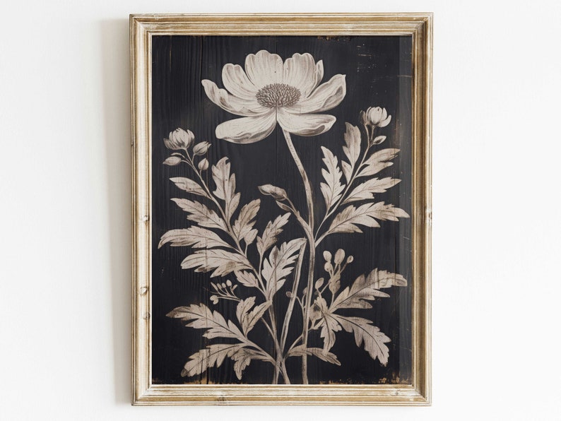 May include: A framed black and white botanical print featuring a single large flower with delicate leaves. The print is set against a dark wood background.