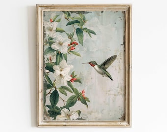 Puede incluir: Impresión enmarcada de estilo vintage con un colibrí en vuelo. La obra presenta flores blancas, hojas verdes y bayas rojas sobre un fondo azul claro. El marco tiene un acabado dorado envejecido.
