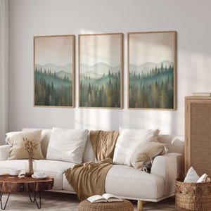 May include: Three framed landscape prints of a forest scene with a white couch, a wooden coffee table, a woven basket, and a wooden cabinet with a woven door in a living room setting.