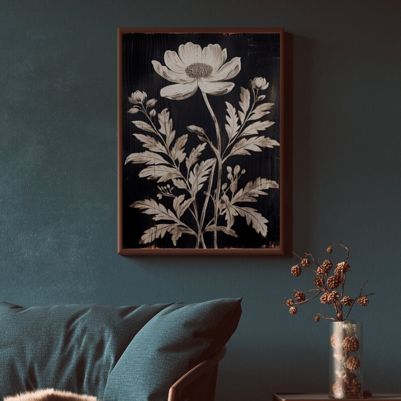 May include: A black and white botanical print of a single flower with leaves on a dark wood background. The print is framed in a brown wood frame.