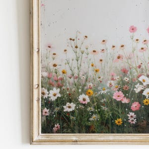 May include: A framed painting of a field of pink, white, and yellow wildflowers. The flowers are painted in a realistic style and are set against a white background.