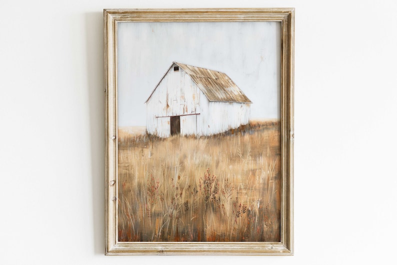 May include: A framed painting of a white barn with a rusty metal roof, standing in a field of tall, dry grass. The barn is painted in a rustic style with faded white paint and a weathered wooden door. The background is a soft, hazy blue sky.