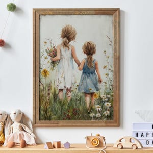 以下が含まれることがあります： 野花が咲く野原を歩く2人の女の子を描いた水彩画の額縁入り作品。女の子たちはドレスを着て、手をつないでいます。絵は薄い青色の空を背景に描かれています。