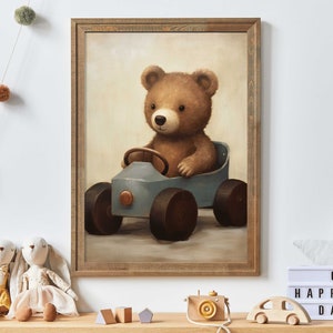 Puede incluir: Un oso de peluche marrón conduciendo un coche de juguete azul. El coche tiene un volante, faros y un parachoques de color cobre. El oso está sentado en el coche con sus patas en el volante. El fondo es de color marrón claro.