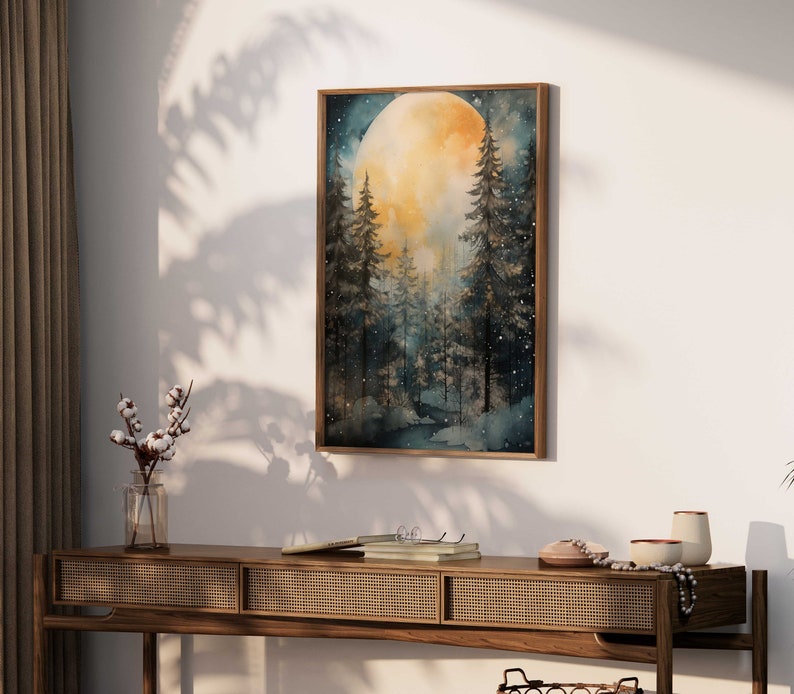 May include: A watercolor painting of a full moon rising over a dark forest. The moon is a bright yellow and the trees are silhouetted against the night sky. The painting is framed in a dark wood frame.