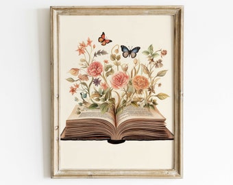 Può includere: Stampa artistica ad acquerello raffigurante un libro aperto con fiori colorati e farfalle che emergono dalle pagine. L'opera è incorniciata in una cornice di legno chiaro e invecchiato, creando un'estetica vintage.