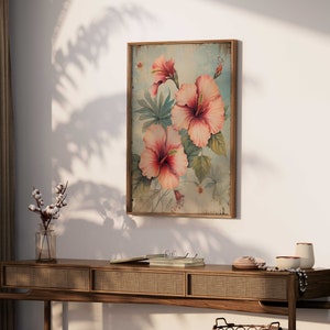 May include: A vintage-style framed print featuring a floral design with pink hibiscus flowers on a light blue background.