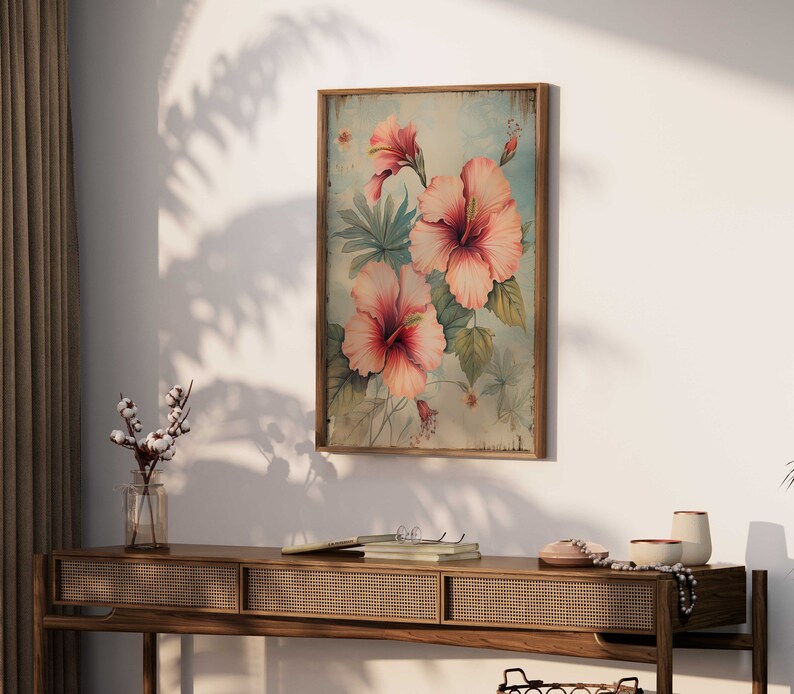 May include: A vintage-style framed print featuring a floral design with pink hibiscus flowers on a light blue background.