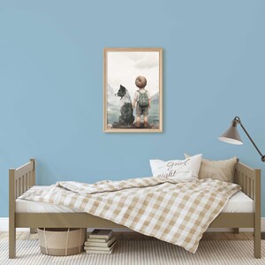 K&ouml;nnte beinhalten: Ein gerahmter Aquarelldruck zeigt ein Kind mit Rucksack und Hund, das eine Berglandschaft betrachtet. Das Kunstwerk wird &uuml;ber einem Bett mit einer beige-wei&szlig; karierten Decke ausgestellt. Ein "Good night" Kissen liegt auf dem Bett.