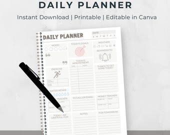 Puede incluir: Un planificador diario blanco con espiral y un bolígrafo negro. El planificador incluye secciones para el estado de ánimo, objetivos, citas, ejercicio y un rastreador de dinero. El texto "DAILY PLANNER" está en la parte superior.