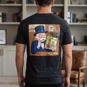 May include: Dark grey t-shirt with a cartoon illustration of a man in a blue suit and top hat, holding a monocle and a book titled "The Berenstain Bears." The image is set against a bookshelf background.