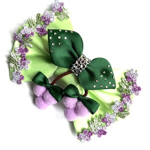 Peut inclure: Ensemble d'accessoires pour cheveux verts et vert clair. L'ensemble comprend un grand nœud avec des strass et un petit nœud avec des pompons violets. Les bords sont ornés de dentelle florale violette et blanche.