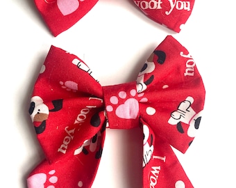 Könnte beinhalten: Zwei rote Hunde-Bowties mit weißen Pfotenabdrücken und dem Text "I woof you".