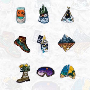 May include: A set of ten embroidered iron-on patches featuring various outdoor adventure themes. The patches include a campfire, a tent, a mountain range, a pair of hiking boots, a jar with palm trees, a lighter, a pair of ski goggles, a pair of lungs with trees, and a hiking boot with the text "Take a Hike".