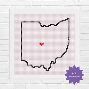 Pode incluir: Uma bordada em ponto cruz emoldurada do estado de Ohio, delineada com pontos pretos, com um coração vermelho no centro. O fundo é um padrão de ponto cruz rosa claro. Um gráfico de estrela roxa no canto inferior direito diz "PDF Download".