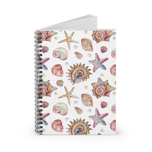 May include: Spiral-bound notebook featuring a white cover adorned with a watercolor pattern of seashells and starfish in shades of pink, orange, and blue. The notebook's design includes various shell types and starfish, creating a coastal theme.