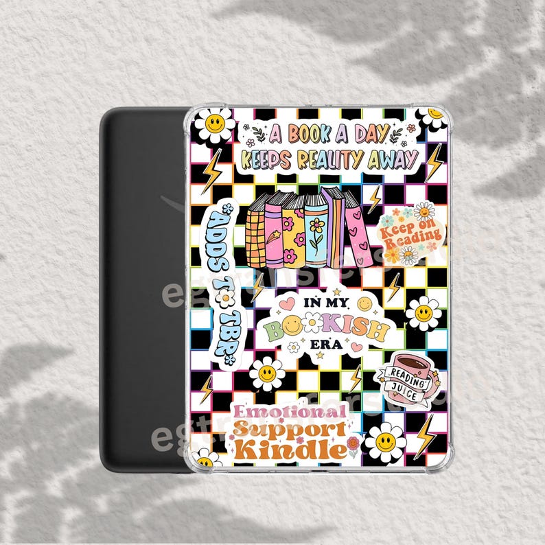 Op de afbeelding: Een doorzichtige Kindle-hoes met een kleurrijk ontwerp. Het ontwerp bevat de tekst "A Book A Day Keeps Reality Away", "Adds to TBR", "In My Bookish Era" en "Emotional Support Kindle". De achtergrond heeft een zwart-wit geruit patroon.
