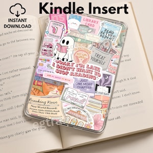 May include: Clear Kindle case decorated with stickers. The stickers feature a ghost reading, the text "Sorry I didn't want to stop reading", and a cat. The case rests on an open book.