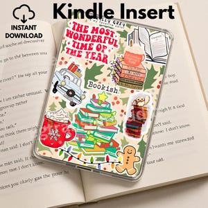 Könnte beinhalten: Kindle-Insert mit festlichem Design. Die Hülle zeigt weihnachtliche Aufkleber, darunter ein Auto mit Geschenken, einen Stapel Bücher, einen Lebkuchenmann und eine Tasse heiße Schokolade. Der Text enthält "The Most Wonderful Time of the Year" und "Bookish."