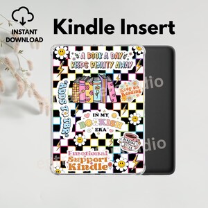 Op de afbeelding: Een transparante Kindle-hoes met een kleurrijk ontwerp met boeken, madeliefjes en bliksemschichten op een zwart-witte geruite achtergrond. Tekst bevat "A Book A Day Keeps Reality Away" en "Emotional Support Kindle."