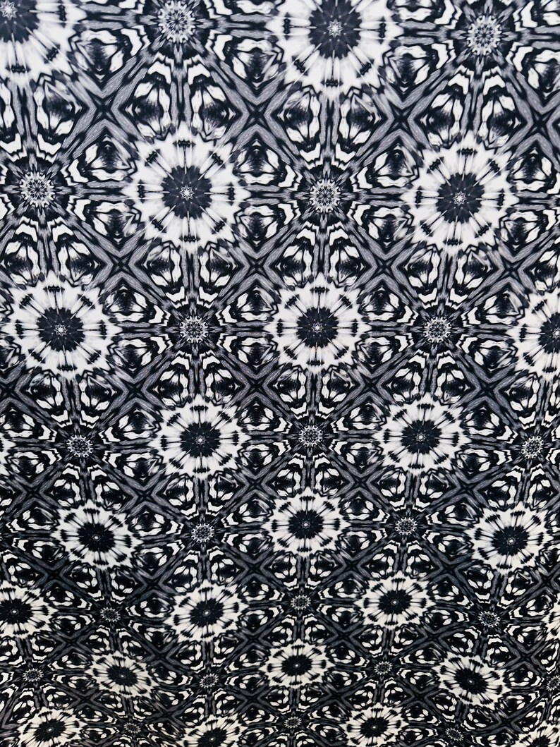 May include: Black and white abstract pattern with a repeating geometric design. The pattern features a series of interlocking circles and squares.