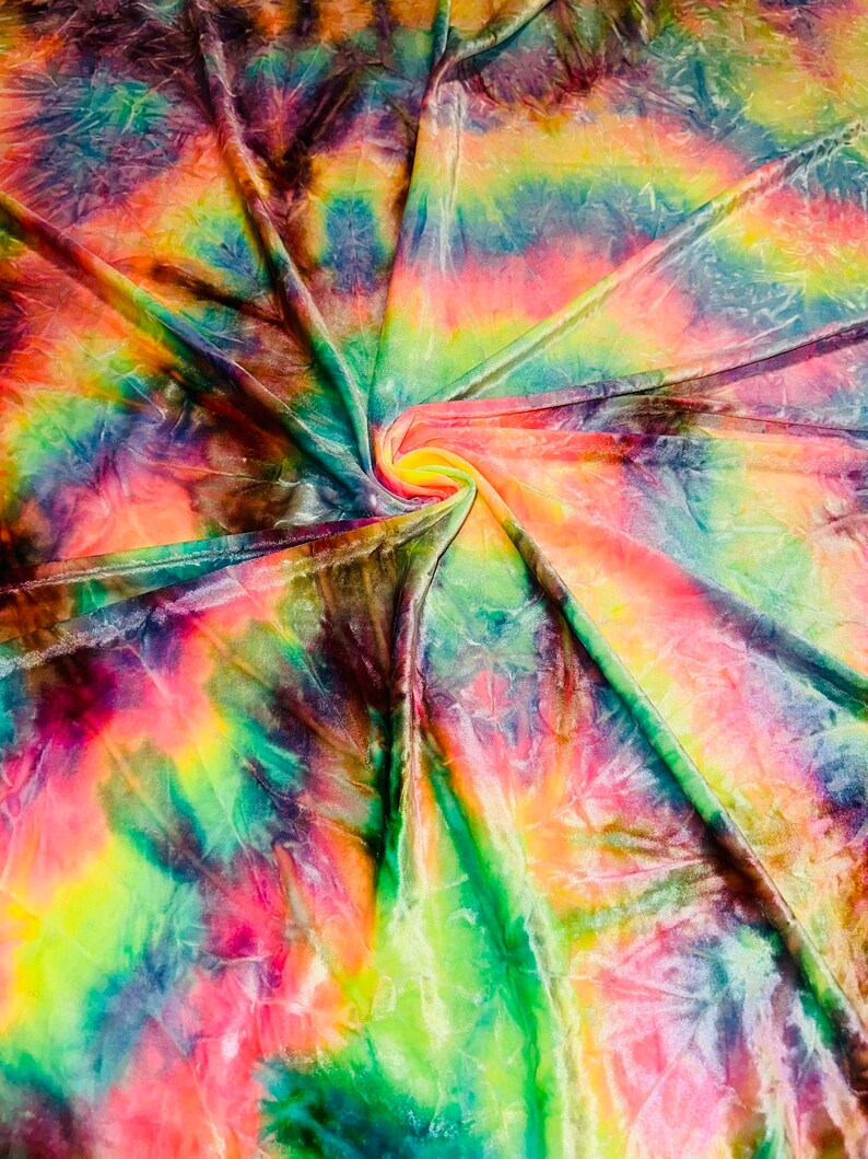 May include: A vibrant, tie-dye fabric with a swirling pattern. The fabric features a blend of colors, including pink, yellow, green, and blue, creating a psychedelic effect. The material appears soft and flowing, with visible folds and textures.
