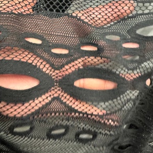 May include: Black sheer fabric with a geometric pattern of holes and a mesh design.