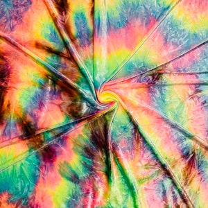 May include: A vibrant, tie-dye fabric with a swirling pattern. The colors include shades of green, yellow, orange, pink, blue, and purple. The fabric is folded and gathered in the center, creating a spiral effect. The overall effect is bright and colorful.