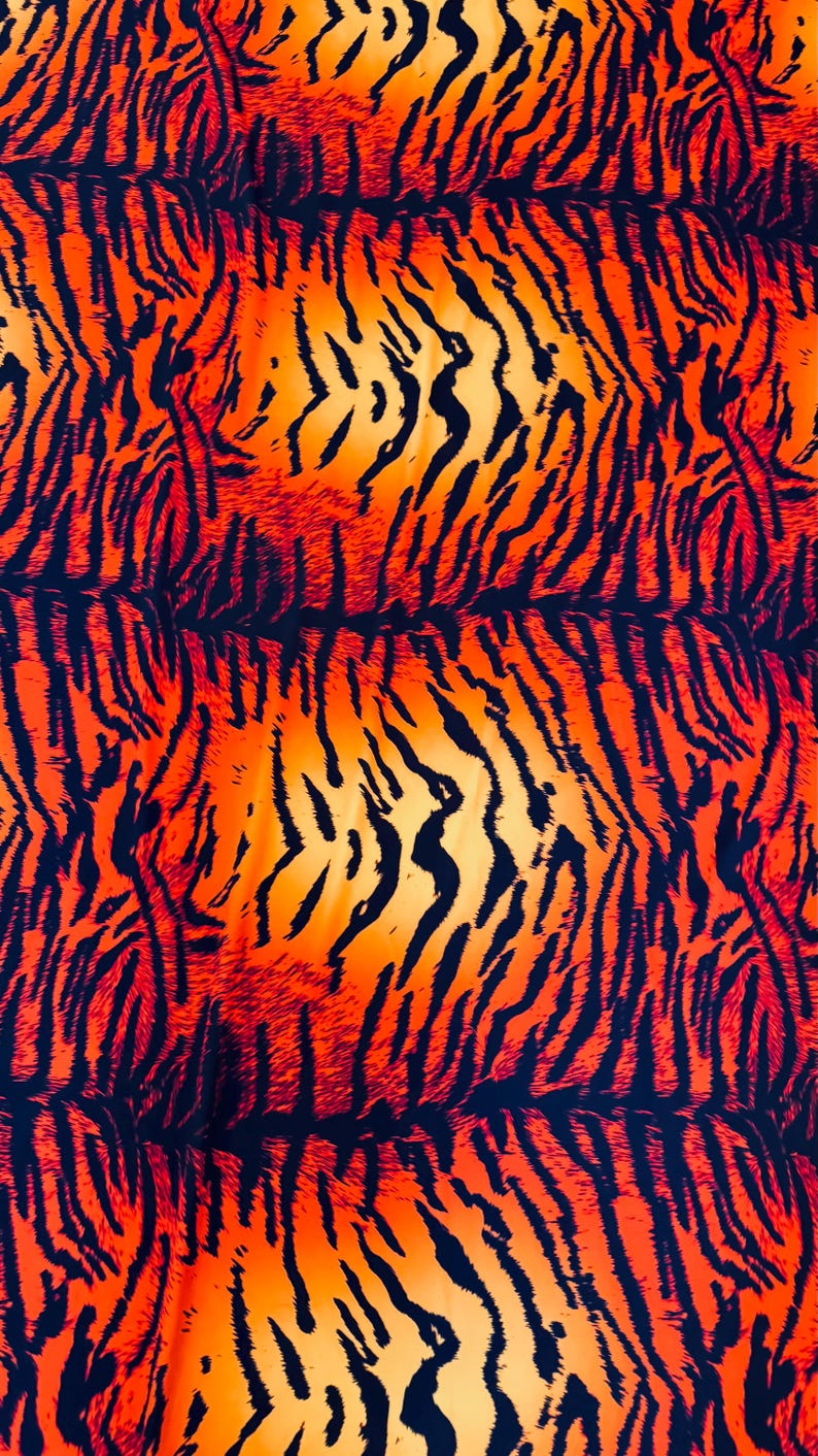 Puede incluir: Un textil vibrante con un estampado de rayas de tigre. El dise&ntilde;o presenta rayas negras sobre un degradado de tonos naranja y amarillo, creando un efecto visual audaz y llamativo.