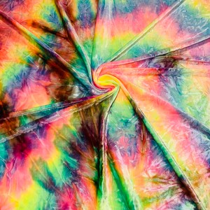 May include: A vibrant, multi-colored fabric with a tie-dye pattern. The colors include shades of pink, yellow, green, blue, and purple. The fabric is swirled and folded, creating a dynamic and textured appearance. The overall effect is bright and eye-catching.
