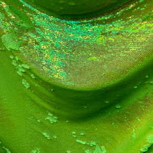 Mermaid sequins iridescent neon green flip up sequins on spandex mesh base 4-way stretch 58/60” Sold by the YD.