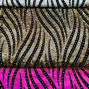May include: Three pieces of fabric with a zebra print pattern. The fabric is iridescent and has black rhinestones on it. The top piece is white, the middle piece is gold, and the bottom piece is pink.