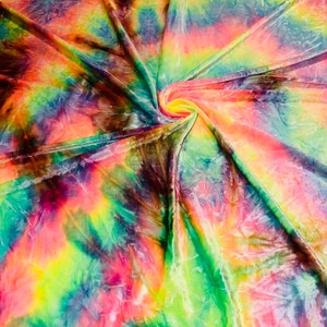 May include: A vibrant, swirled fabric with a tie-dye pattern. The colors include shades of pink, yellow, green, blue, and purple. The fabric is gathered in the center, creating a spiral effect. The material appears soft and flowing.