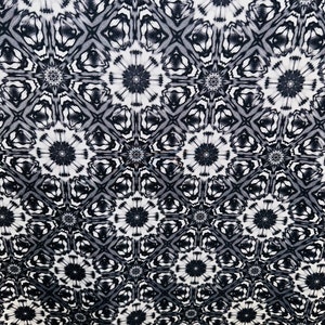 May include: Black and white fabric with a repeating pattern of stylized flowers and geometric shapes.