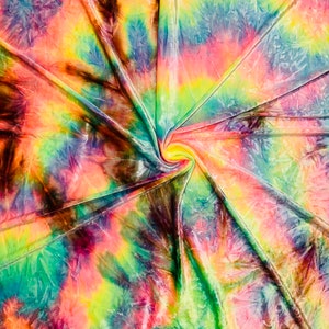 May include: A vibrant tie-dye fabric with a swirling pattern. The colors include shades of pink, yellow, green, blue, and brown. The fabric is folded and gathered in the center, creating a spiral effect. The overall effect is bright and colorful.