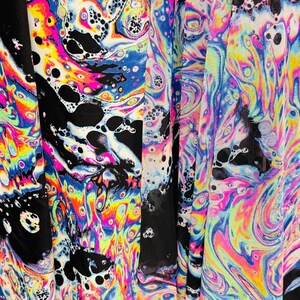 Puede incluir: Tela negra transparente con un patr&oacute;n de remolino iridiscente de colores. La tela tiene una textura de malla y es perfecta para manualidades o para hacer ropa.