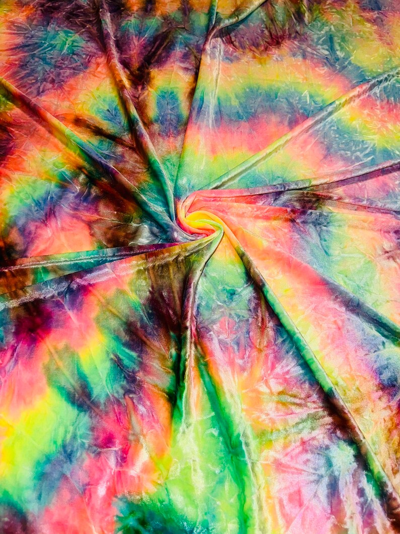 May include: A vibrant, tie-dye fabric with a swirling pattern. The fabric features a blend of colors, including pink, yellow, green, blue, and purple. The material is folded and gathered, creating a dynamic and textured appearance.
