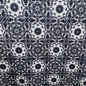 May include: Black and white fabric with a repeating geometric pattern of stars and diamonds. The fabric has a soft, flowing texture.
